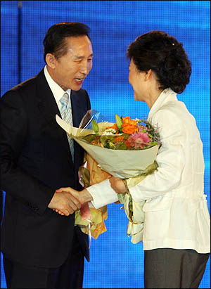 2007년 8월 20일 한나라당 전당대회에서 제17대 대통령 후보로 선출된 이명박 후보가 득표 2위를 차지한 박근혜 후보에게 다가가 손을 내밀고 있다.
